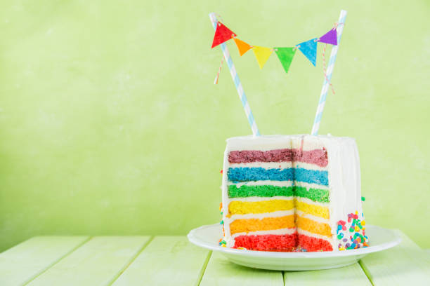 istock Birthday background - striped rainbow cake with white frosting 922953928
