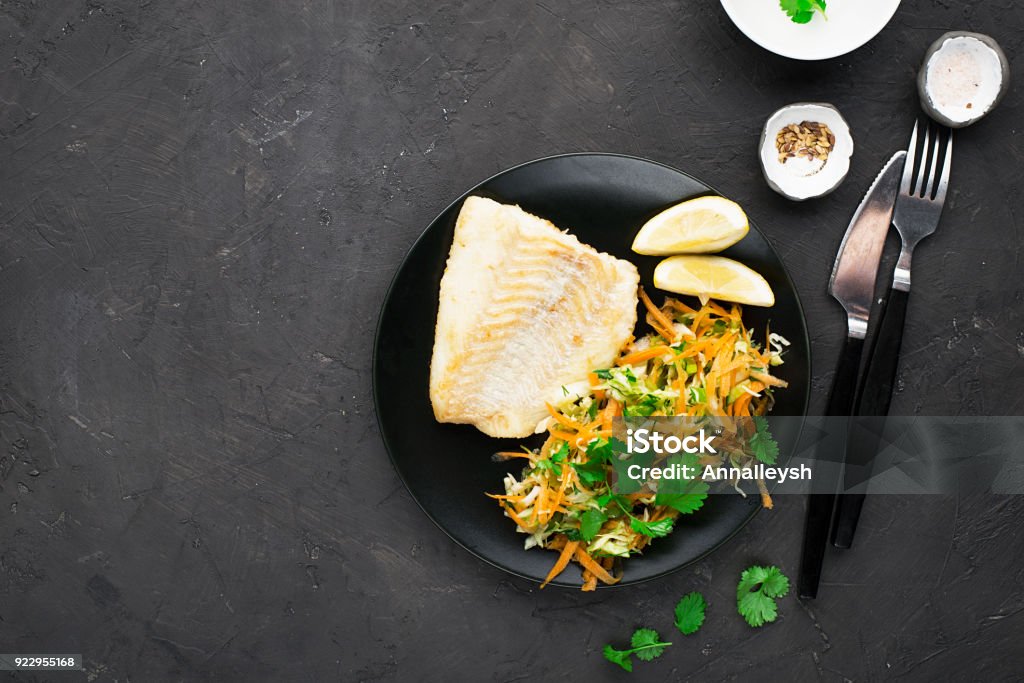 Fried cod with salad from fresh carrots, cabbage, cucumber and dill. Top view. Horizontal Cod Stock Photo