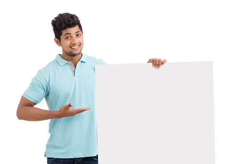 Smart young man holding white board isolated on white.