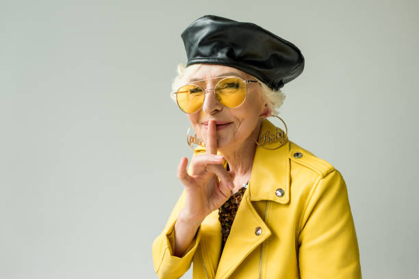 istock stylish senior woman with silence symbol 922965580