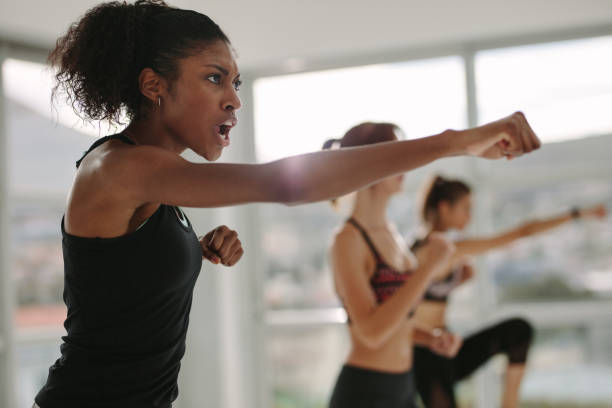 strong young females exercising in gym - effort dark concepts women imagens e fotografias de stock