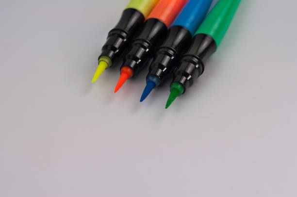 istock Row of colored markers brushes on white school desk or office table with copy space 922970038