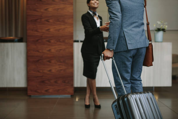 Concierge welcoming guest at hotel lobby Female concierge welcoming business man at hotel lobby. Receptionist greeting guest at hotel hallway. hotel stock pictures, royalty-free photos & images