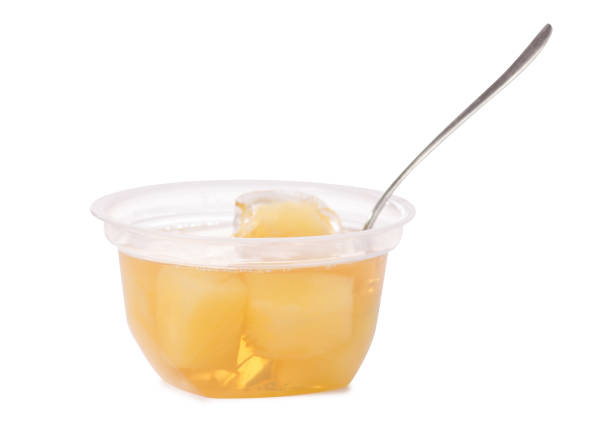 istock Cup of jelly with fruit yellow pineapple with spoon isolation 922973944