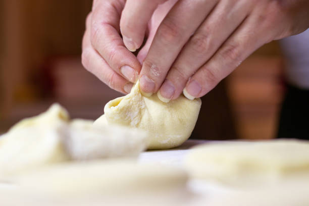 istock Beautiful woman hands making dough 922982032