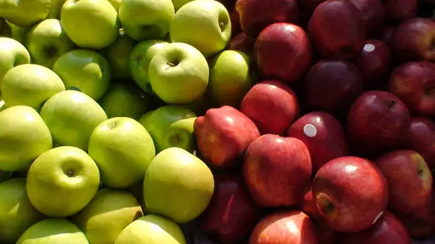 display of red and gren apples on a market