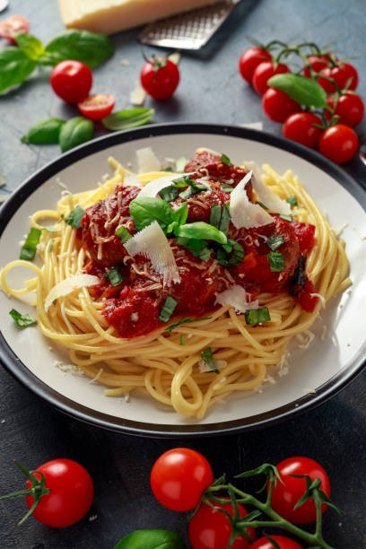 istock Spaghetti pasta meatballs with tomato sauce, basil, herbs parmesan cheese on dark background 922993070