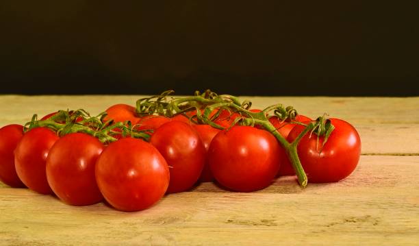 istock Fresh cherry tomatoes on rustic wooden background. White and black background. Copy space for text 922996168