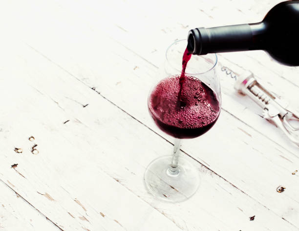 verter vino tinto de botella de vidrio de vino de mesa vintage de madera blanca con copyspace. - wine pouring wineglass white wine fotografías e imágenes de stock