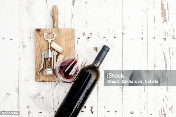 A Glass Of Red Wine Bottle Corkscrew And Wine Corks On Rustic Board Over White Wooden Table Copyspsce Wine Tasting Conceptn Stock Photo - Download Image Now