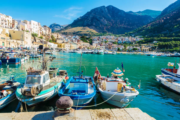 Fishing port with old wooden fishing boats in Sicily, Italy Fishing port with old wooden fishing boats docked at the marina in summer in Castellammare del Golfo in Sicily, Italy sicily photos stock pictures, royalty-free photos & images