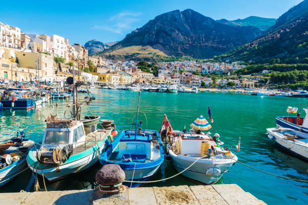 Fishing port with old wooden fishing boats in Sicily, Italy Fishing port with old wooden fishing boats docked at the marina in summer in Castellammare del Golfo in Sicily, Italy fish village stock pictures, royalty-free photos & images