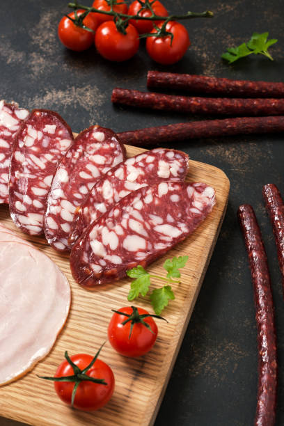 istock Smoked chopped sausage on a cutting board with cherry tomatoes. 923006804