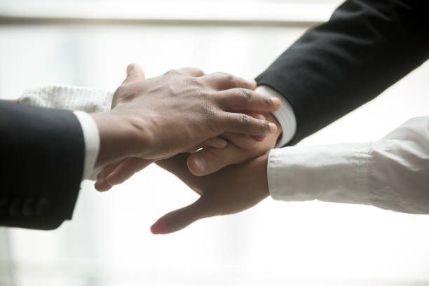 istock African and caucasian partners put hands together, close up view 923018898
