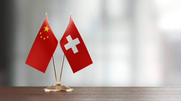 istock Chinese And Swiss Flag Pair On A Desk Over Defocused Background 923024138