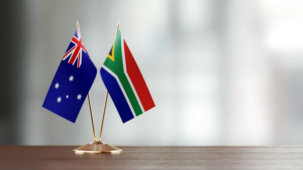 istock Australian And South African Flag Pair On A Desk Over Defocused Background 923024370