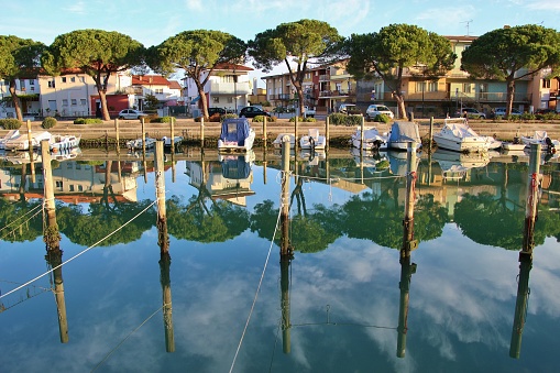 Canal and boats in Grado in bright morning light. North-East Italy, Europe.