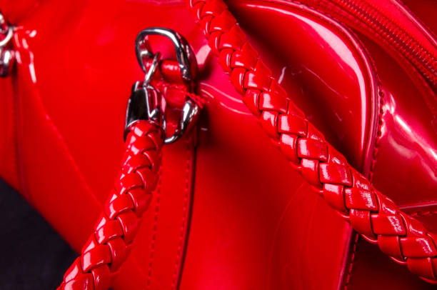 fittings on the leather hand bag closeup of buckles, clasps, zippers, pockets, fasteners, fittings and seams on the red lacquer hand bag tineola stock pictures, royalty-free photos & images