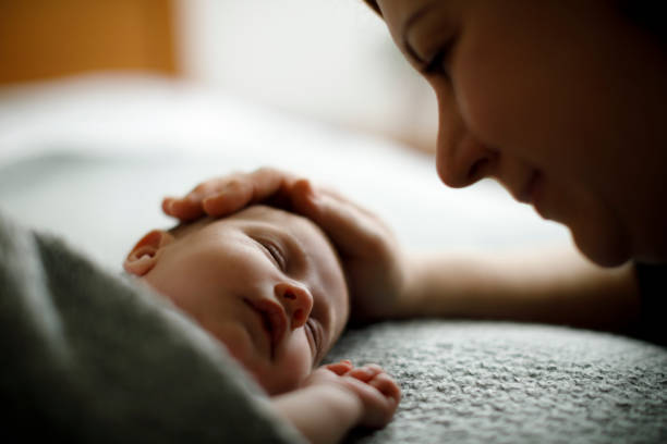 istock Mother caressing her newborn sleeping baby 923028716