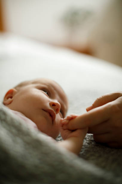 Newborn baby holding mother's hand