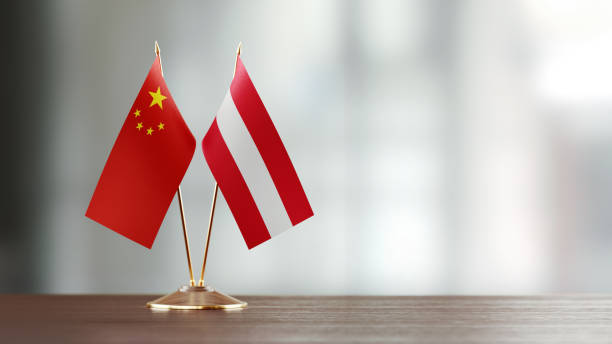 istock Chinese And Austrian Flag Pair On A Desk Over Defocused Background 923030924
