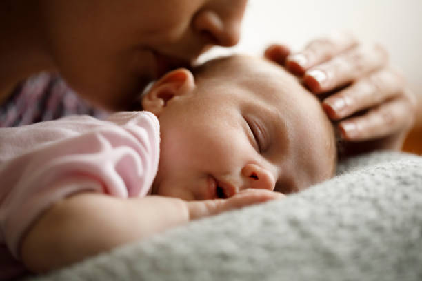 Mother kissing her sleeping baby