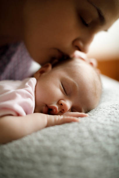 istock Mother kissing her sleeping baby 923032698
