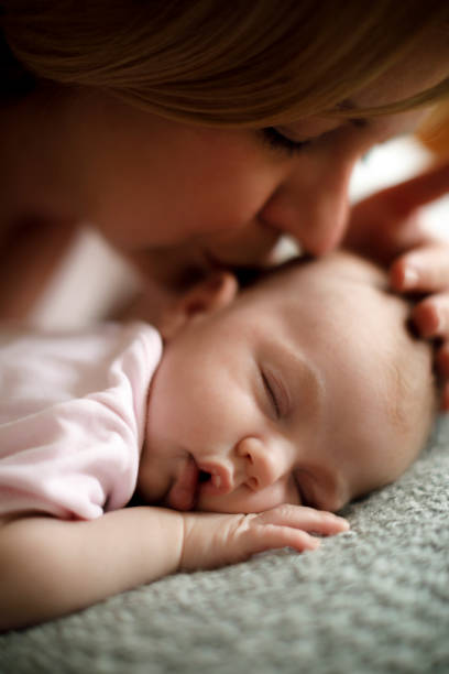 istock Mother kissing her sleeping baby 923034878
