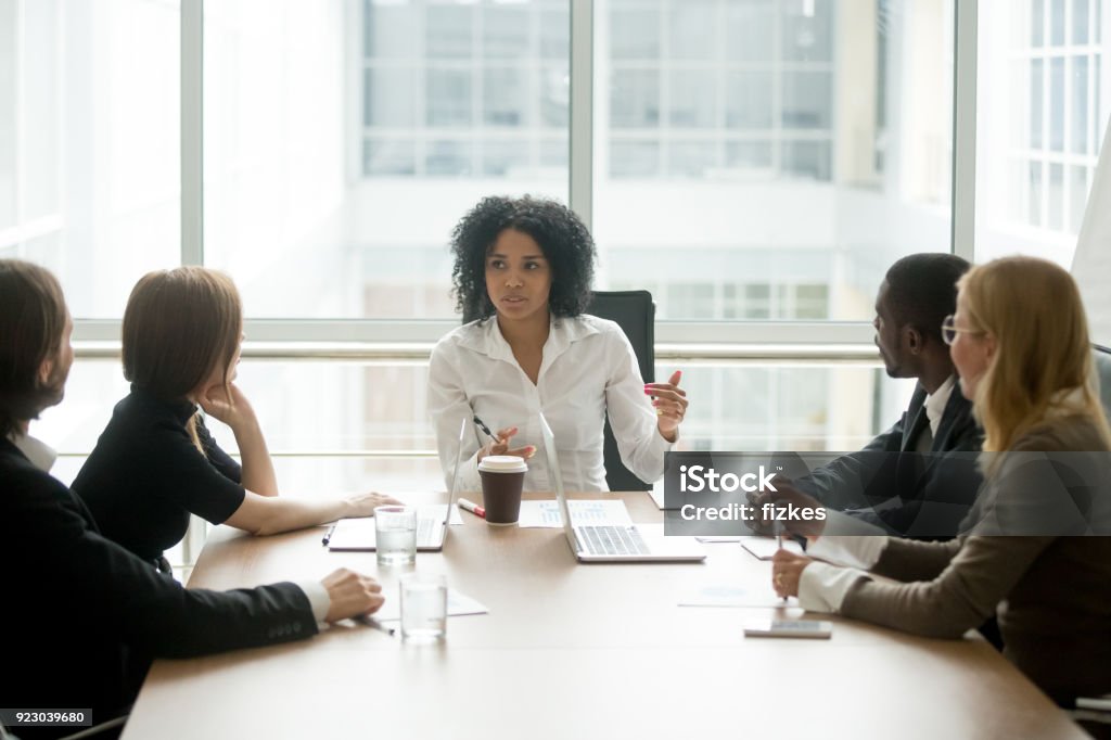 Negro mujer jefe liderando reuniones corporativas hablando con empresarios diversos - Foto de stock de Liderazgo libre de derechos