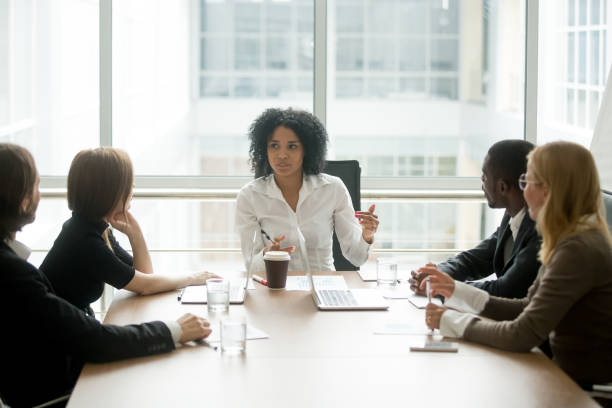 Black female boss leading corporate meeting talking to diverse businesspeople Black female boss leading corporate multiracial team meeting talking to diverse businesspeople, african american woman executive discussing project plan at group multi-ethnic briefing in boardroom gender equality stock pictures, royalty-free photos & images