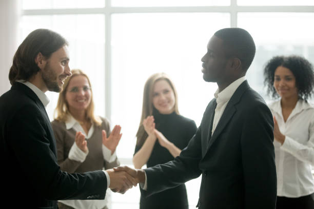 istock Ceo with team appreciating black manager by handshake and applause 923039924