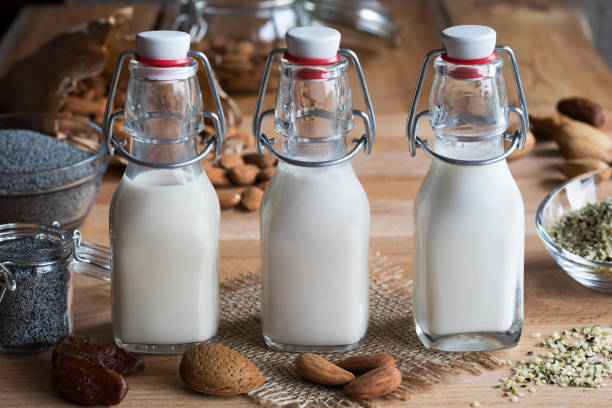 trois bouteilles de lait de plante végétalien - lait d’amande, lait de graines de pavot et lait de graine de chanvre - hemp seed nut raw photos et images de collection