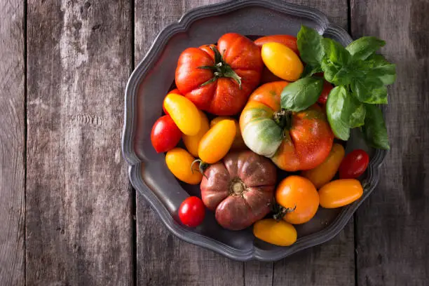 Colorful tomatoes, red , yellow, orange , green,black tomatoes. autumn background. vintage wooden background