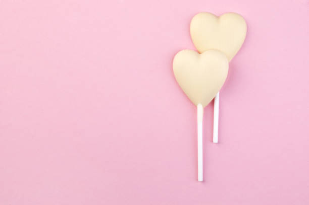 istock Two white chocolate candy hearts on pink 923069106