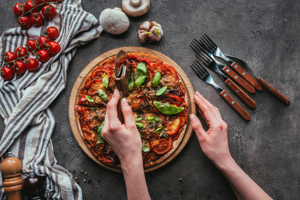 istock top view of slicing pizza with circle cutter on concrete table 923075266