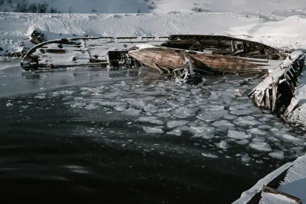 Photo of Parts of abandoned ships at northern coast at winter. Teriberka, Kola Peninsula. Russia
