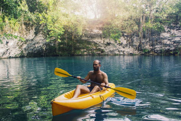 Young man kayaking on yellow boat stock photo