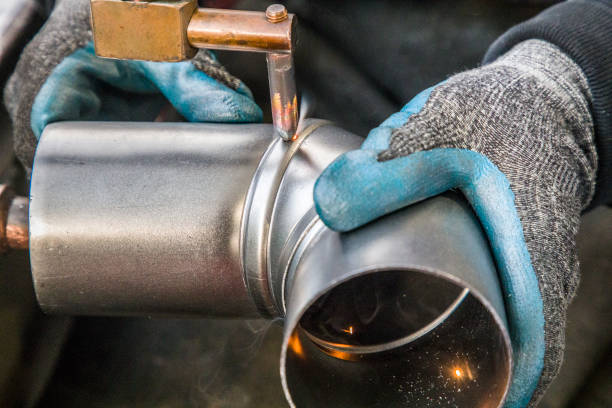 Worker welding metal piping using tig welder