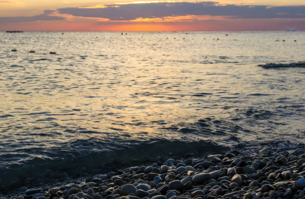 istock Amazing sea sunset on the pebble beach, the sun, waves, clouds 923078274