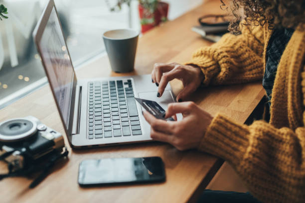 Online shopping Woman in cafe shopping online with laptop high tech business cards stock pictures, royalty-free photos & images