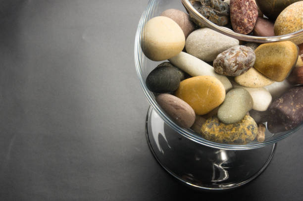 multicolored decorative pebbles in glass containers on a black background