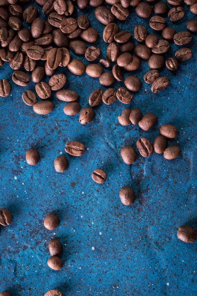 roasted coffee beans on blue table, can be used as a background