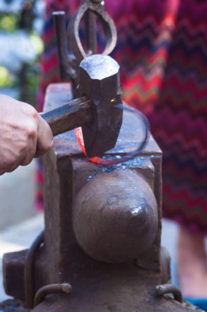 istock blacksmith performs the forging of hot glowing metal on the anvil 923089054