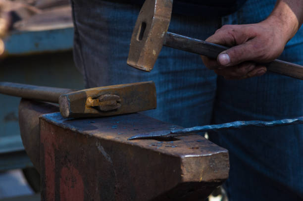 istock blacksmith performs the forging of hot glowing metal on the anvil 923089290
