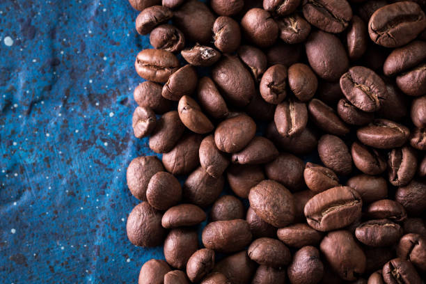istock roasted coffee beans on blue table, can be used as a background 923092296