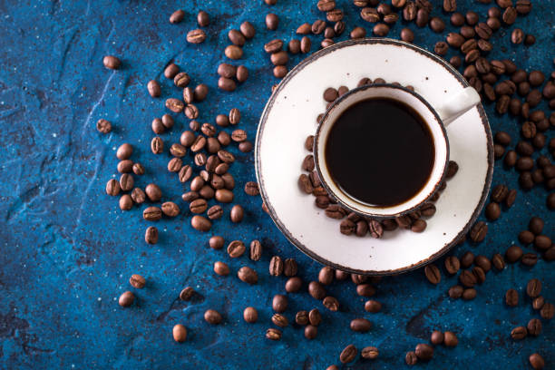 istock Coffee cup and coffee beans on a dark blue table 923092670