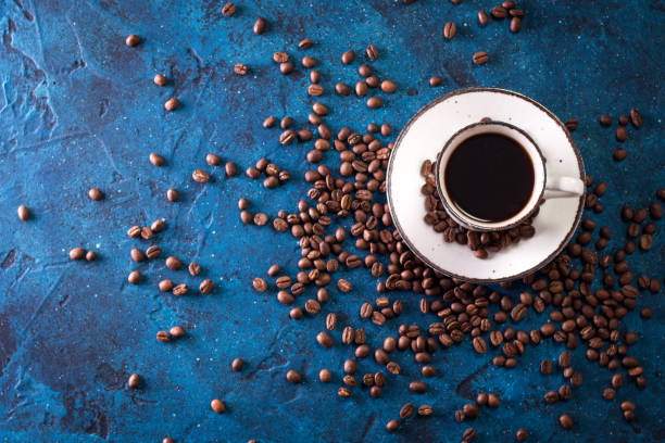 istock Coffee cup and coffee beans on a dark blue table 923092844