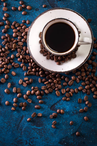 istock Coffee cup and coffee beans on a dark blue table 923093038