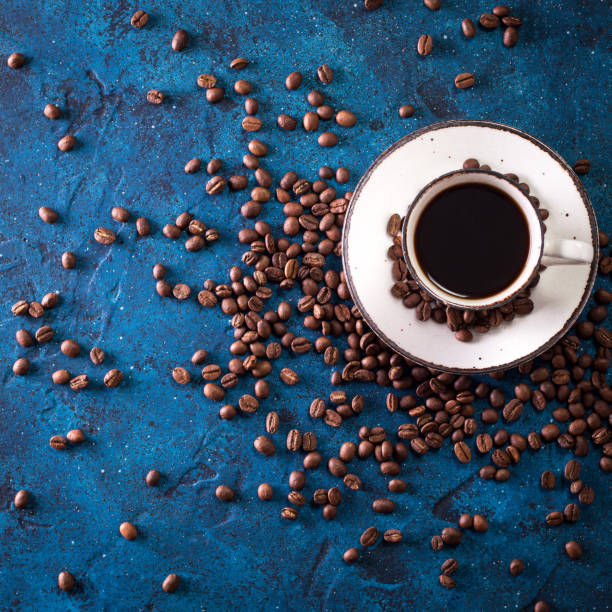 istock Coffee cup and coffee beans on a dark blue table 923093648
