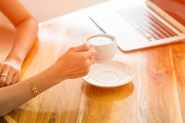 istock business Woman Hand Holding Coffee Cup and Working 923093834